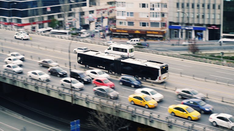Aerial view of city traffic with cars and a metrobus on a busy roadway.